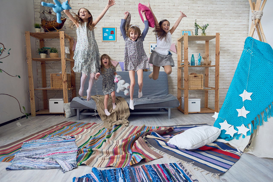 Meninas pulando e brincando na sala de casa